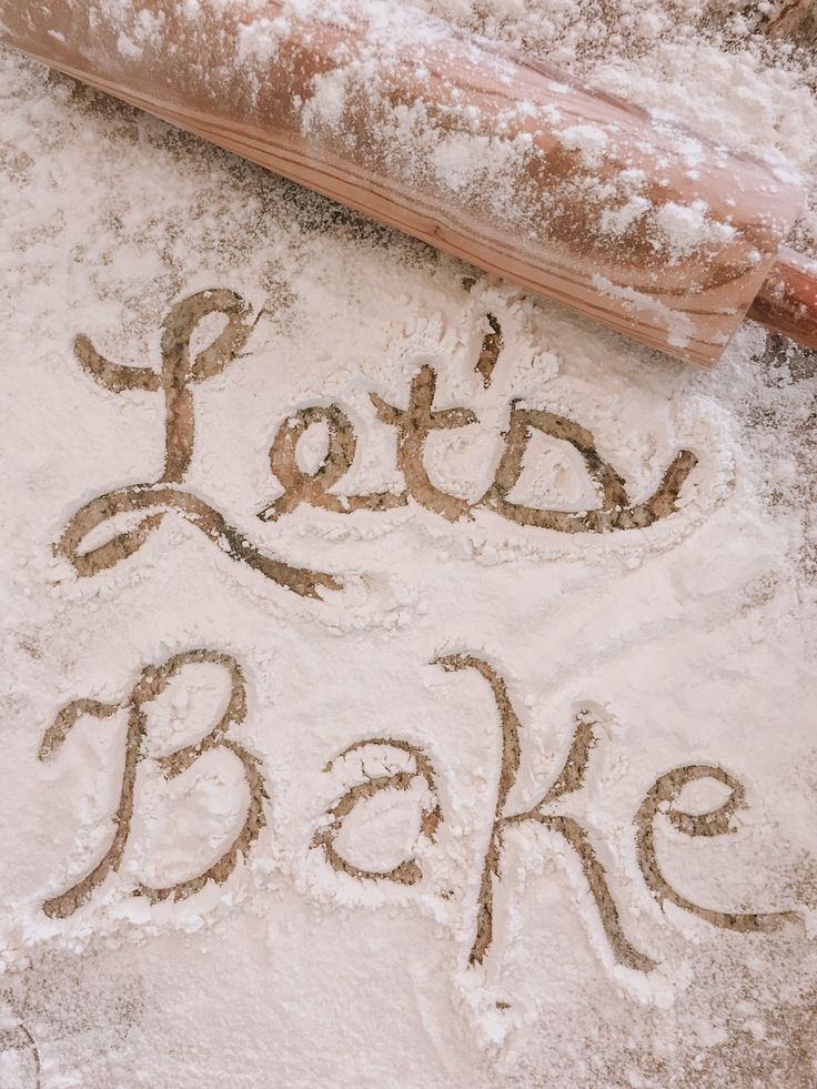 Let's Bake written by hand in flour beside a wooden rolling pin